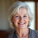 Portrait of Maria G., a smiling woman in her early 60s.